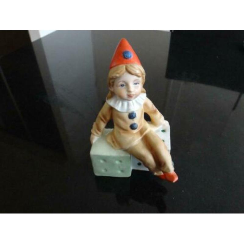 beeldje, pierrot, clown, zit op 2 dobbelstenen, rode muts