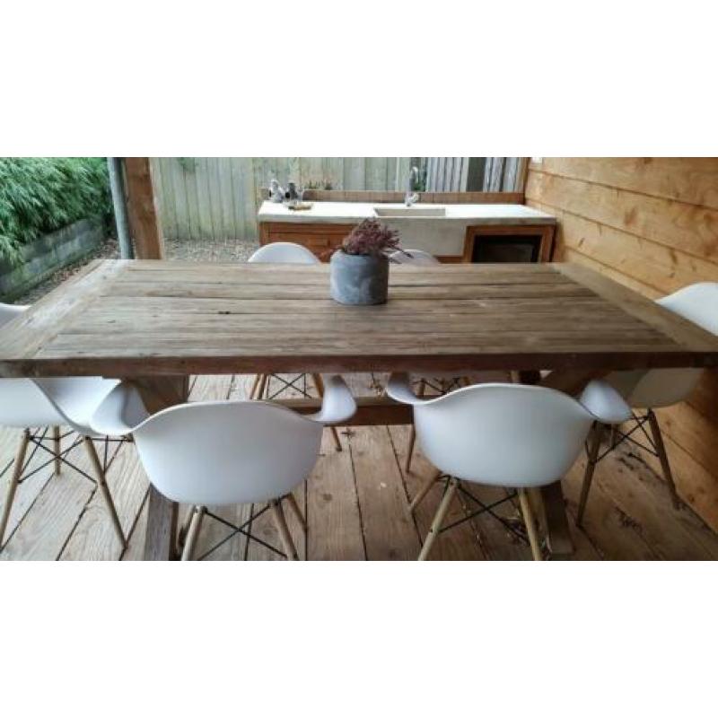 Zware houten tuintafel met 6 witte kuipstoeltjes.