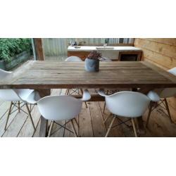 Zware houten tuintafel met 6 witte kuipstoeltjes.