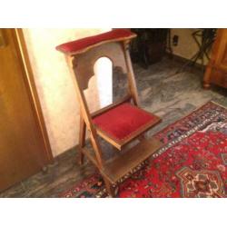Bid stoel met fluwelen rode bekleding.