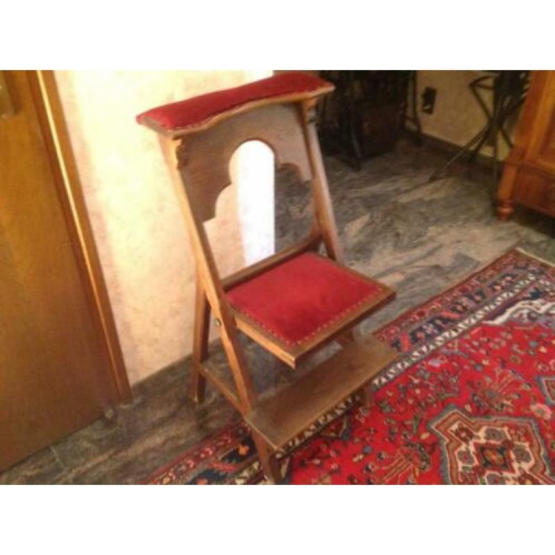 Bid stoel met fluwelen rode bekleding.