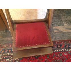 Bid stoel met fluwelen rode bekleding.
