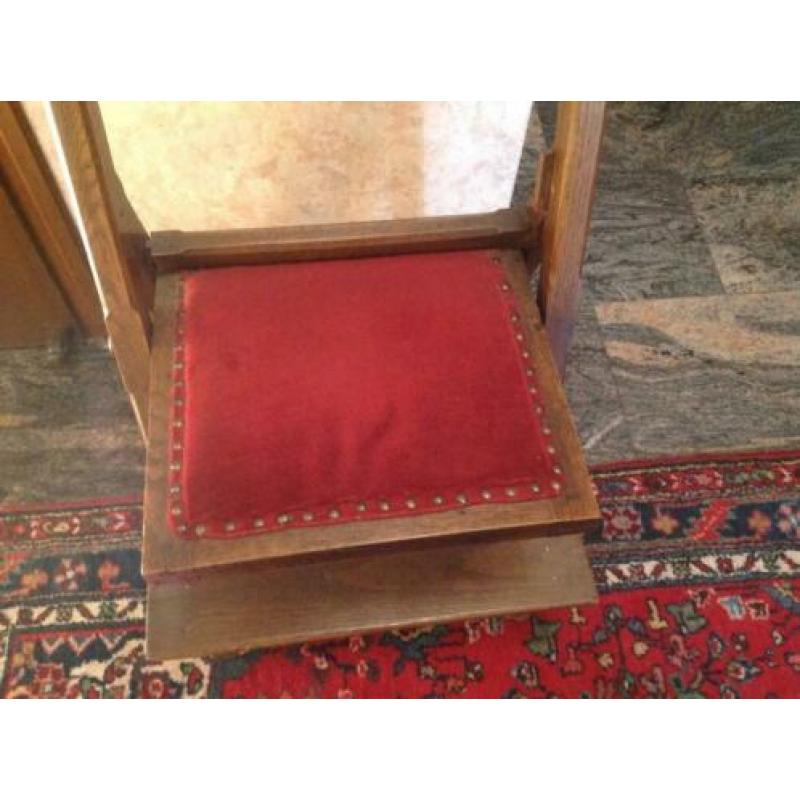 Bid stoel met fluwelen rode bekleding.