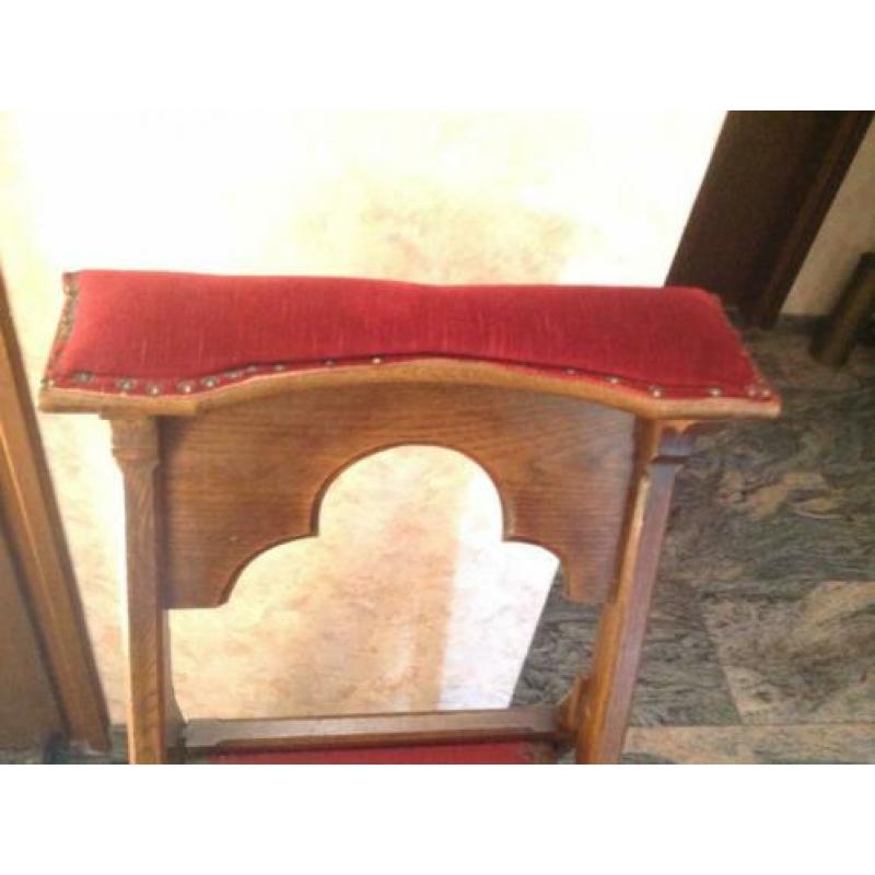 Bid stoel met fluwelen rode bekleding.