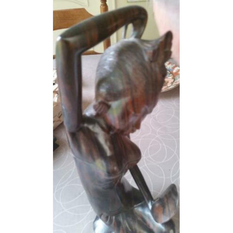 Houten sculptuur van meisje die haar toilet maakt met spiege