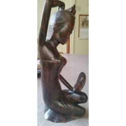 Houten sculptuur van meisje die haar toilet maakt met spiege