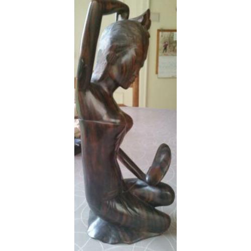 Houten sculptuur van meisje die haar toilet maakt met spiege