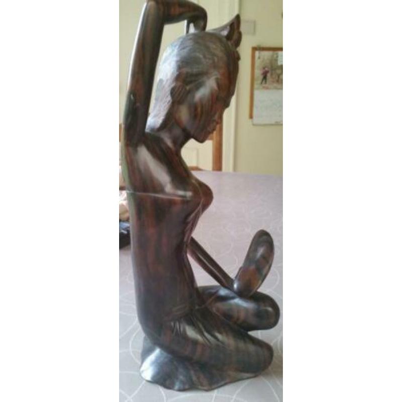Houten sculptuur van meisje die haar toilet maakt met spiege