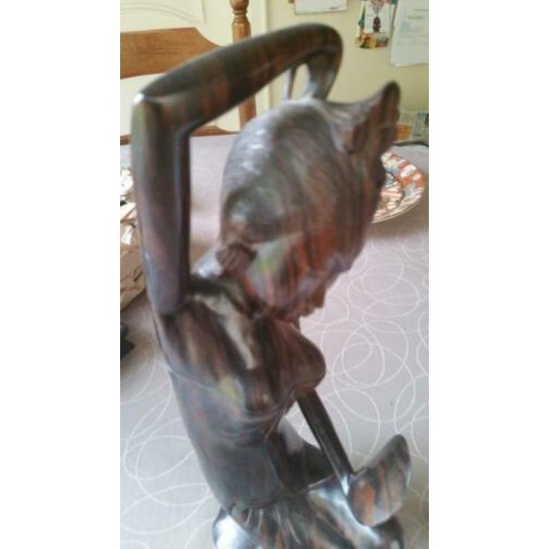 Houten sculptuur van meisje die haar toilet maakt met spiege