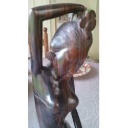 Houten sculptuur van meisje die haar toilet maakt met spiege